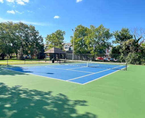 a blue and green tennis court with a black scoreboard