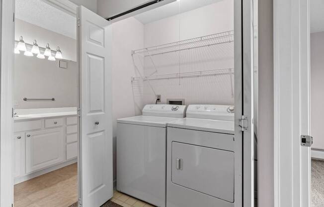 A white bathroom with a washer and dryer.