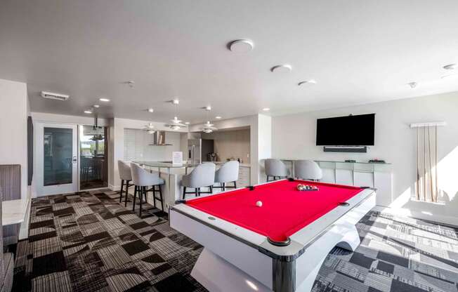 a red pool table in a room with a bar and a television
