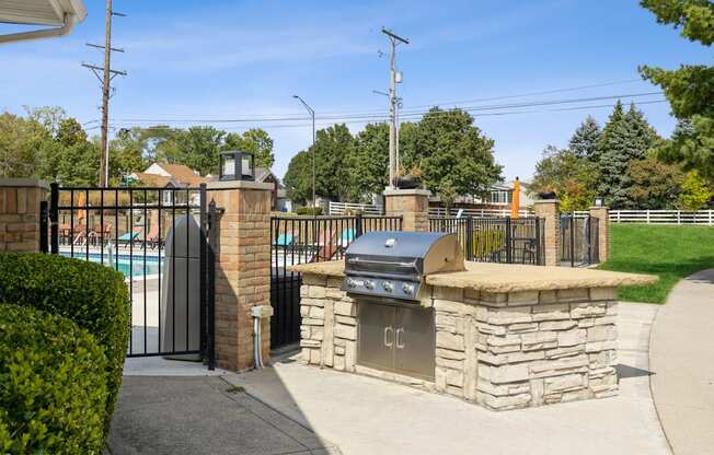 a bbq area with a pool and a wrought iron fence