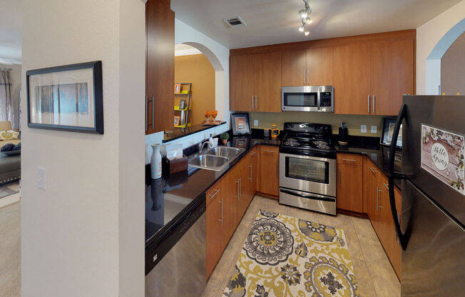 Kitchen with black granite countertops; open to living room