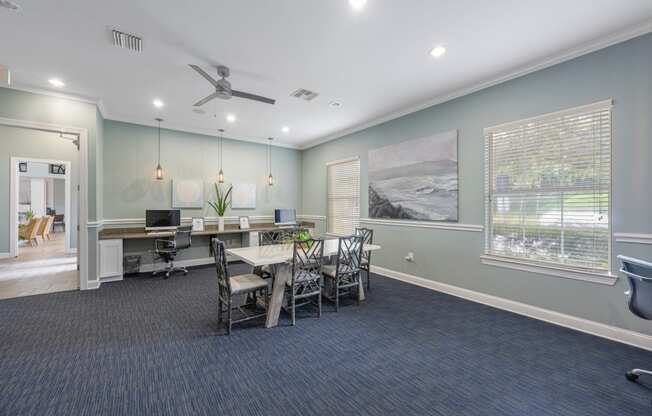 a conference room with a table and chairs and a ceiling fan