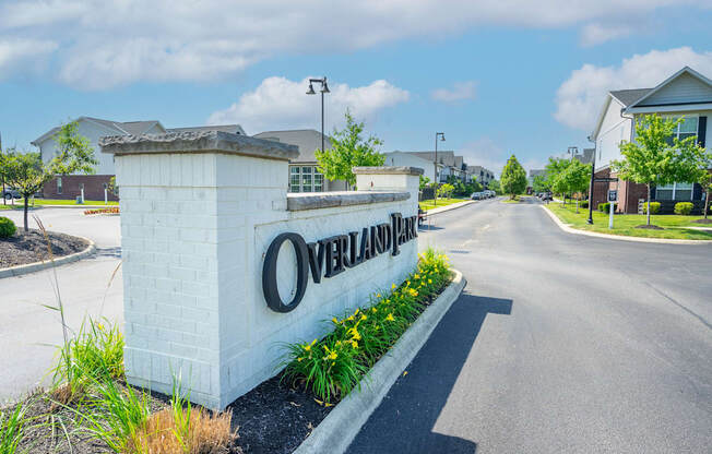 A sign that says Overland Park stands in the middle of a road.