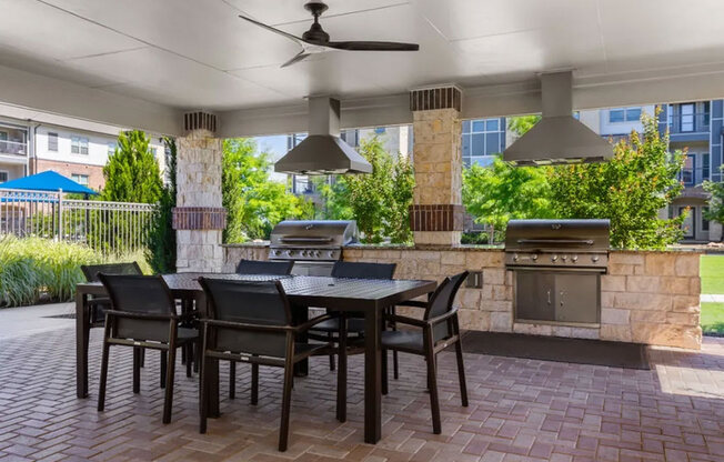 A patio with a table and chairs and a fireplace.