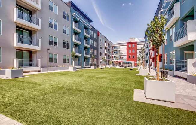 A grassy area in front of apartment buildings.