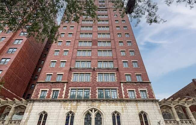 a tall brick building with cars parked in front of it