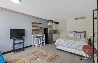 A bedroom with a bed, a chair, and a television.