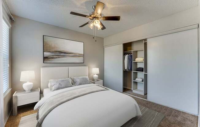 A bedroom with a large bed and a ceiling fan.