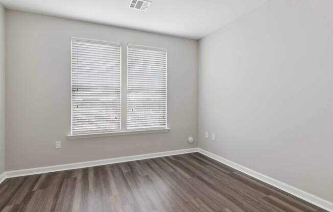 a bedroom with hardwood floors and a large window at Metro 303, Hempstead