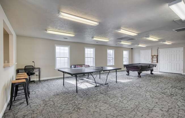 a games room with two ping pong tables and a foosball table