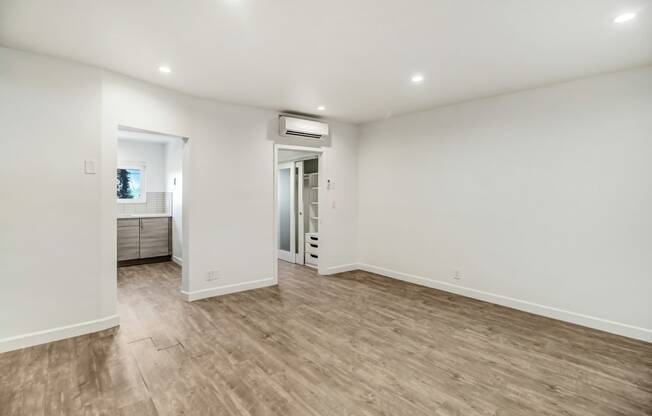 a living room with white walls and a wooden floor