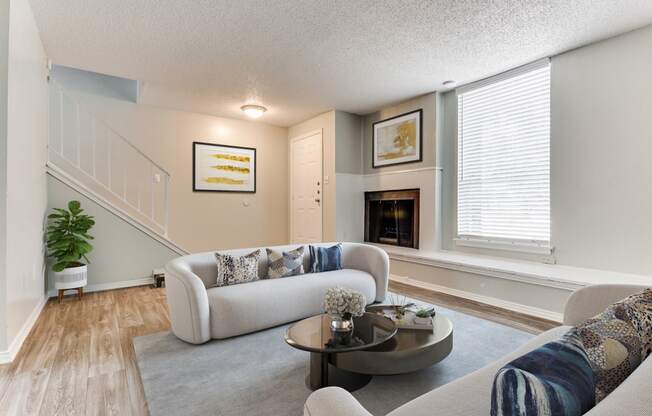 a living room with a couch and a table in front of a fireplace