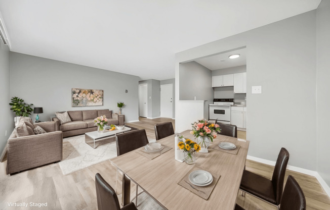 A modern dining room with a wooden table set for two.