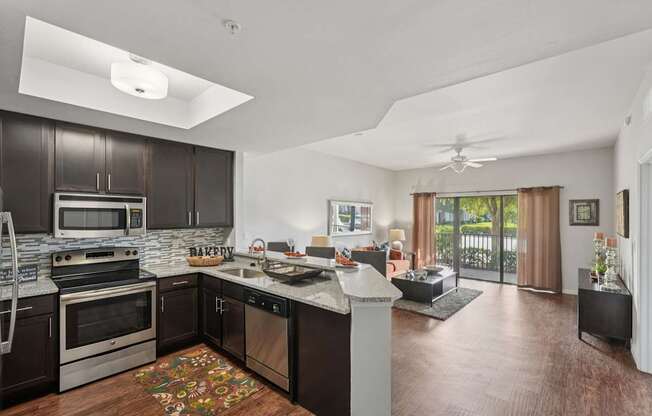 A modern kitchen with dark wood cabinets and stainless steel appliances.