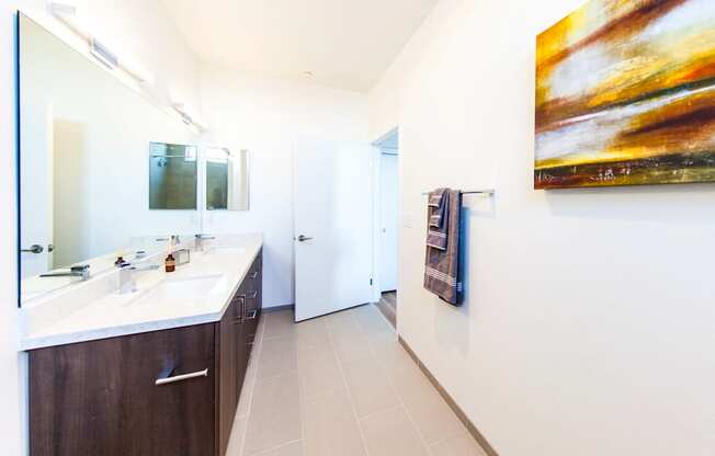 a bathroom with a sink and a painting on the wall