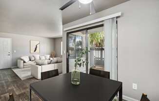 a dining area with a table and chairs and a living room with a couch and a door