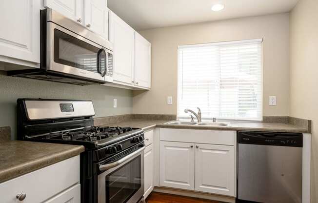 a kitchen with white cabinets and stainless steel appliances at Sagewood Gardens Senior Apartments, Hacienda Heights, CA 91745