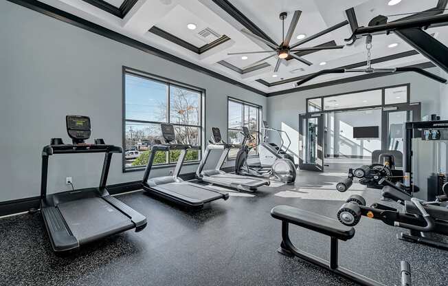 A spacious gym with treadmills, elliptical machines, and a rowing machine.
