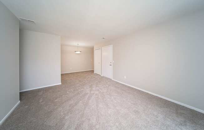open room with carpet and white walls