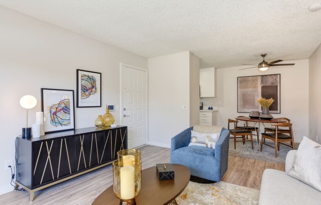 a living room with a couch and a chair and a dining room table