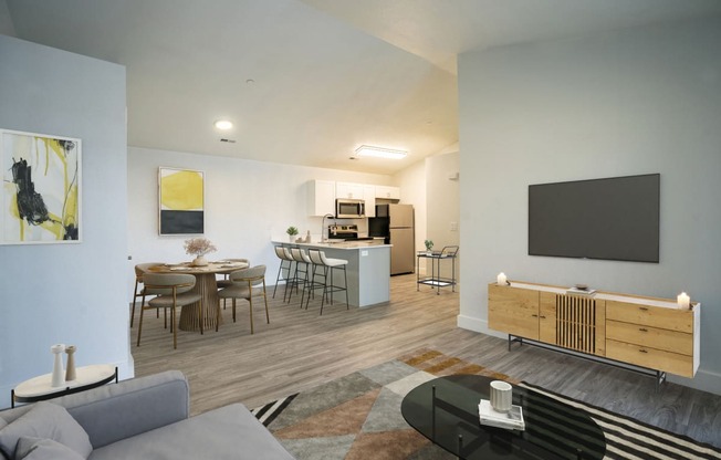 an open living room and kitchen area with a dining table and chairs