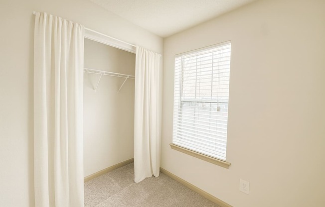 A room with a window and a curtain.