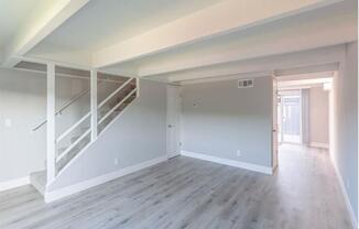 an empty living room with white walls and a staircase at The Preston at Hillsdale, San Mateo, 94403