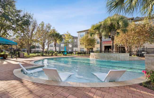A pool with a waterfall and a fountain in the middle.
