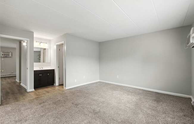 A spacious room with a carpeted floor and white walls.