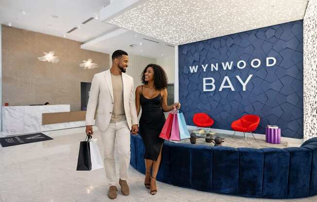 A man and woman are standing in front of a Wynwood Bay sign.