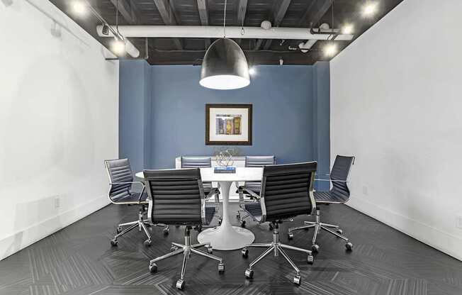A conference room with a white table and chairs.