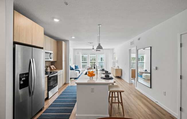 an open kitchen and dining area with a large island and stainless steel appliances at Altis Grand Suncoast, Florida