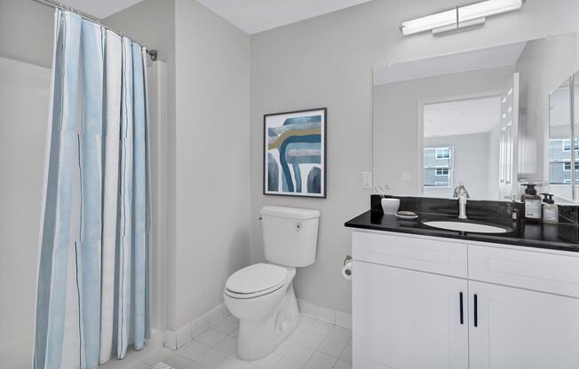 a bathroom with a toilet and a sink and a shower