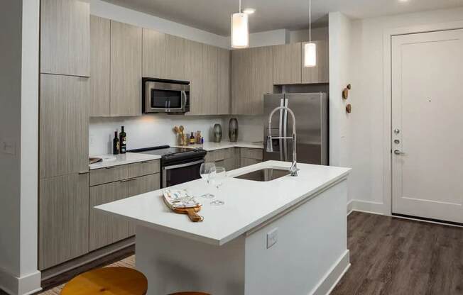 A kitchen with a white island and wooden floors.