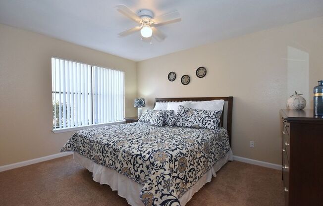 a bedroom with a bed and a ceiling fan