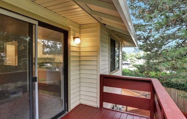 a deck with a red railing and a sliding glass door