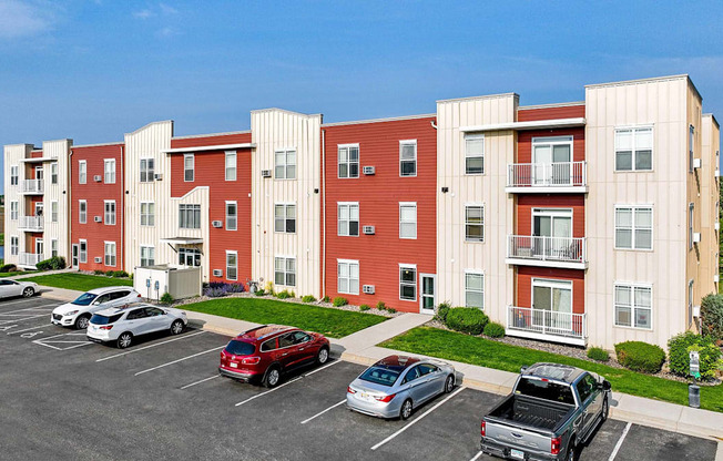Apartment building with cars parked in front.at The Ponds at Heritage Place, Sartell, MN