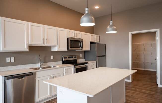 a kitchen with white cabinets and stainless steel appliances. Fargo, ND 29 West Apartments