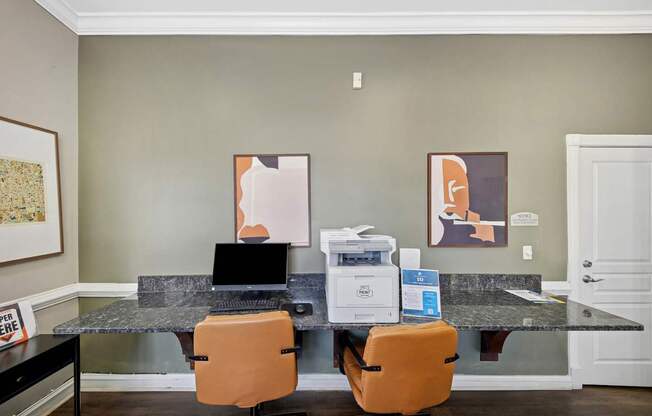 A room with a desk and two chairs.