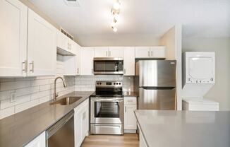 a kitchen with white cabinets and stainless steel appliances