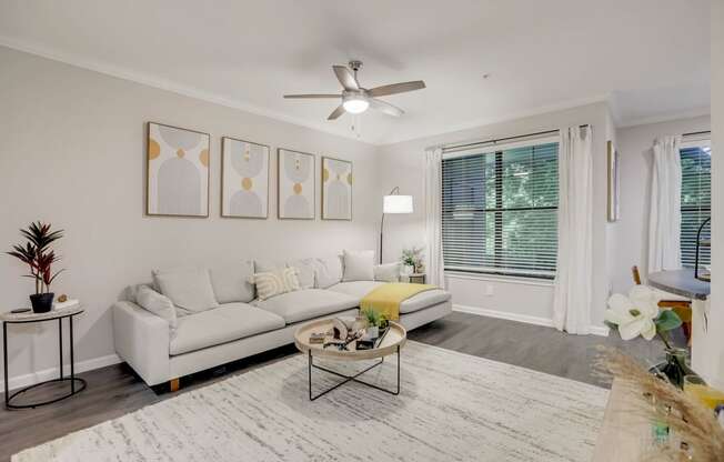 a living room with a white couch and a ceiling fan at The Vista on Brodie, Texas