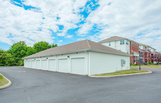 a garage with white doors and a building in the background