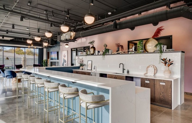 the bar area of a restaurant with white counter tops and blue stools