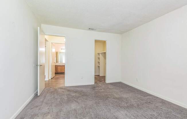 A large, empty room with a carpeted floor and white walls.