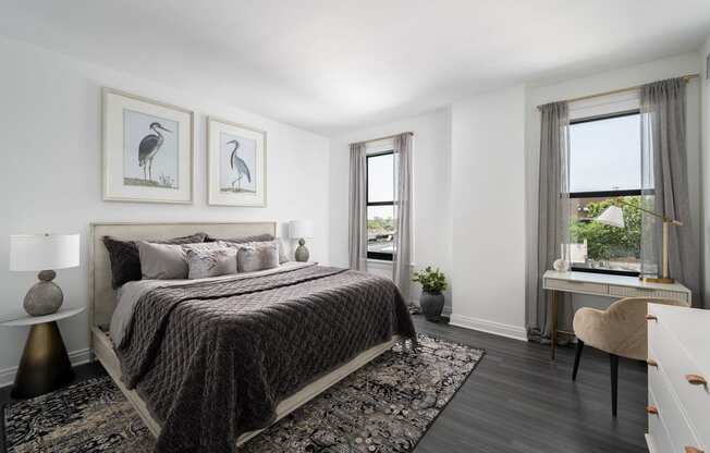 a bedroom with a bed and two windows  at The Belden Stratford, Chicago, IL