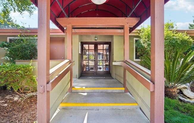 a covered walkway leading to a building with a door