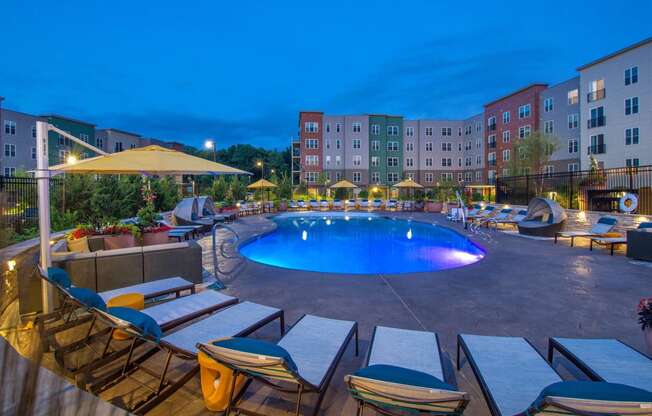 a swimming pool at night at an apartment complex