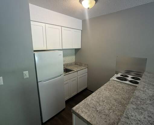 a kitchen with white appliances and granite counter tops