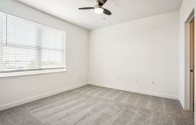 a bedroom with a ceiling fan and a window at Meadowbrooke Apartment Homes, Grand Rapids, 49512