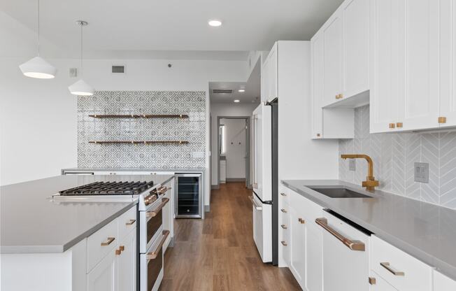 a large white kitchen with white cabinets and white counter tops and a wood floor